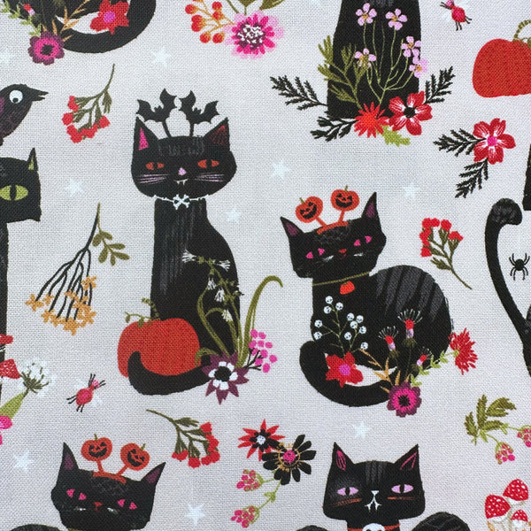 Close up of Hocus Pocus Witchy Whiskers cotton fabric by Helen Black featuring cats, bats, and pumpkins on a beige background