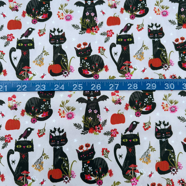 Scale of Hocus Pocus Witchy Whiskers cotton fabric by Helen Black featuring cats, bats, and pumpkins on a beige background