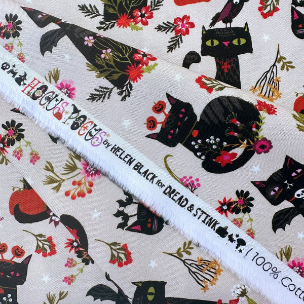 Selvage of Hocus Pocus Witchy Whiskers cotton fabric by Helen Black featuring cats, bats, and pumpkins on a beige background