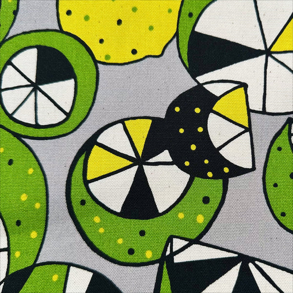 Close up of Imported from Japan, cotton oxford fabric featuring a lemon and lime print in yellow and green on a gray background