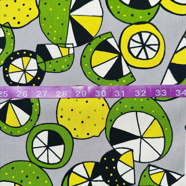 Scale of Imported from Japan, cotton oxford fabric featuring a lemon and lime print in yellow and green on a gray background