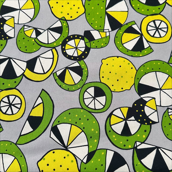 Imported from Japan, cotton oxford fabric featuring a lemon and lime print in yellow and green on a gray background