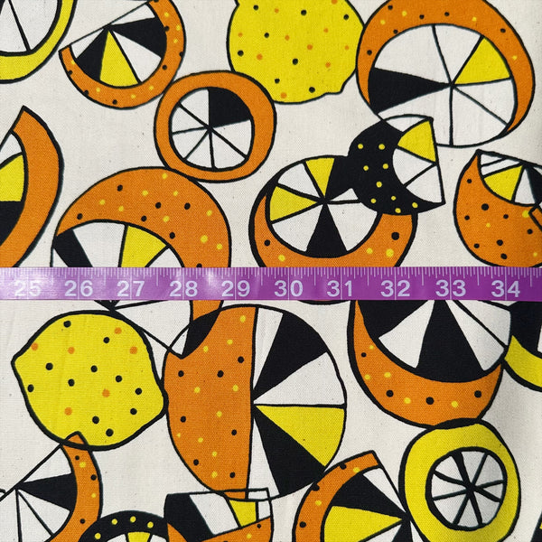 Scale of cotton oxford fabric featuring a lemon and lime print in yellow and green on a natural background, Imported from Japan