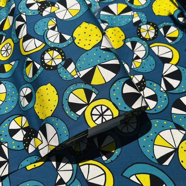 Bolt of Imported from Japan, cotton oxford fabric featuring a lemon and lime print in yellow and green on a teal background
