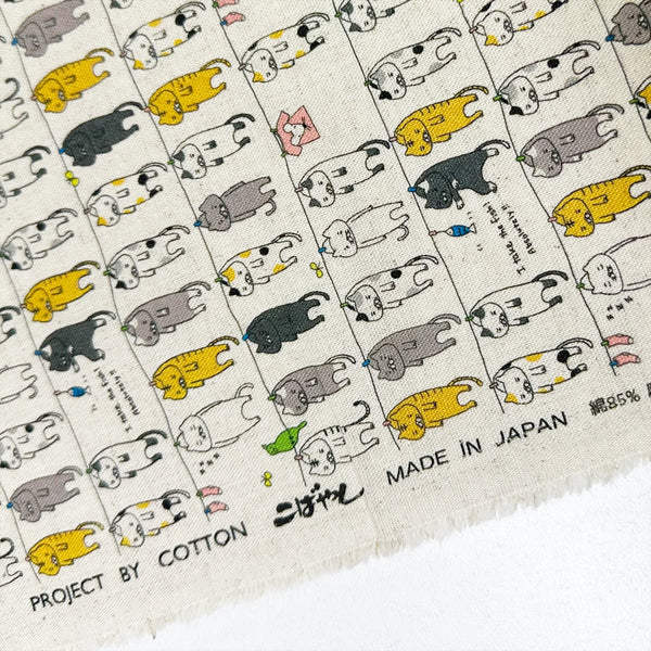 Selvage of Laundry Cats canvas fabric in natural by Cotton Kobayashi, cotton linen blend with silly cats on a clothesline