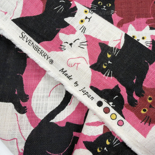 Selvage of Lounge Cats textured cotton fabric by Sevenberry in pink, white, and black
