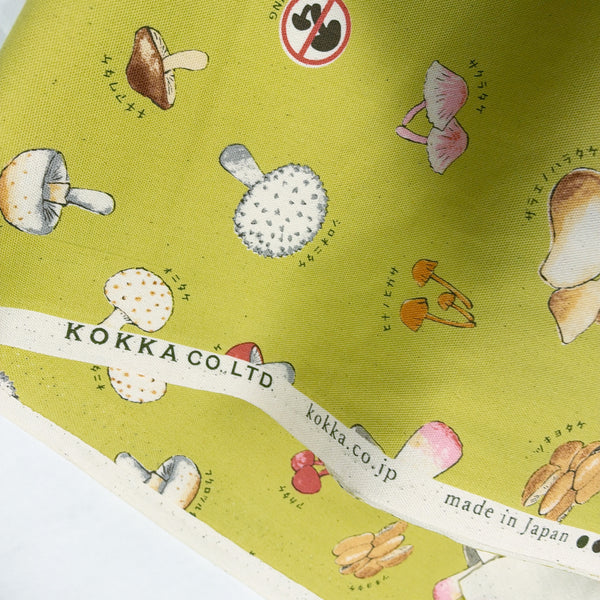 Selvage of Mushroom cotton oxford fabric by Kokka in muted chartreuse, YPA-71000 1B