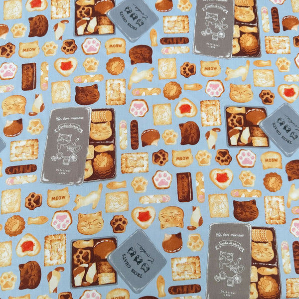 Neko Cookie Can cotton Oxford fabric by Komu Strada featuring cat-shaped cookies, biscuits, and cookie tins on a blue background