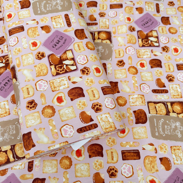 Bolt of Neko Cookie Can cotton Oxford fabric by Komu Strada featuring cat-shaped cookies, biscuits, and cookie tins on a pink background