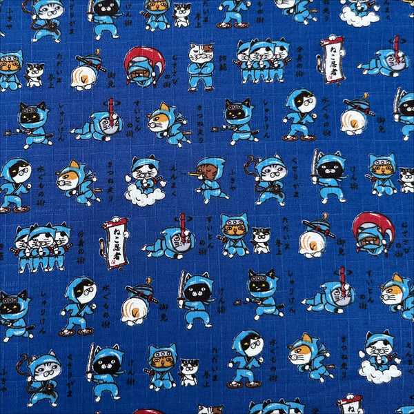 Neko Ninja blue cotton dobby fabric by Cosmo Textiles, imported from Japan. Features playful ninja cats on a textured cotton fabric.
