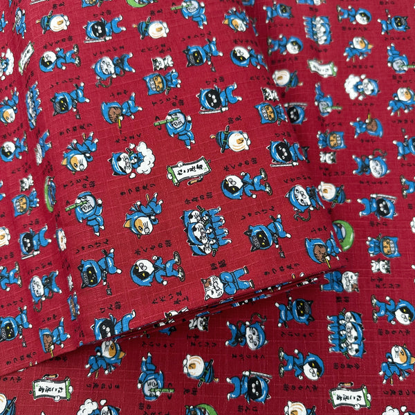 Bolt of Neko Ninja cotton dobby fabric in crimson by Cosmo Textiles Imported from Japan