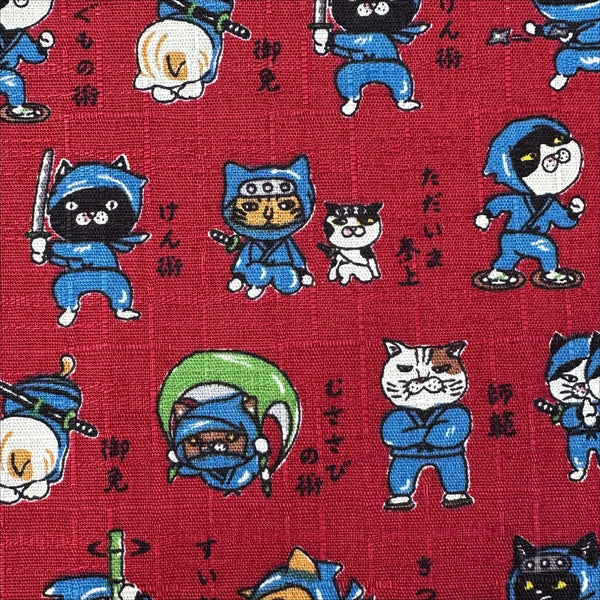 Close up of Neko Ninja cotton dobby fabric in crimson by Cosmo Textiles Imported from Japan