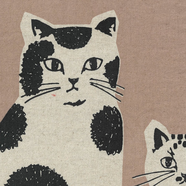 Close up of NekoNoe Echino Cat Cotton Linen Canvas Fabric by Etsuko Furuya for Kokka Japan, featuring playful cat designs in sand and black
