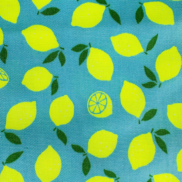 Close up of Neon Lemons cotton oxford fabric by Cosmo Textiles in blue, featuring neon yellow lemons