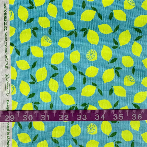 Scale of Neon Lemons cotton oxford fabric by Cosmo Textiles in blue, featuring neon yellow lemons