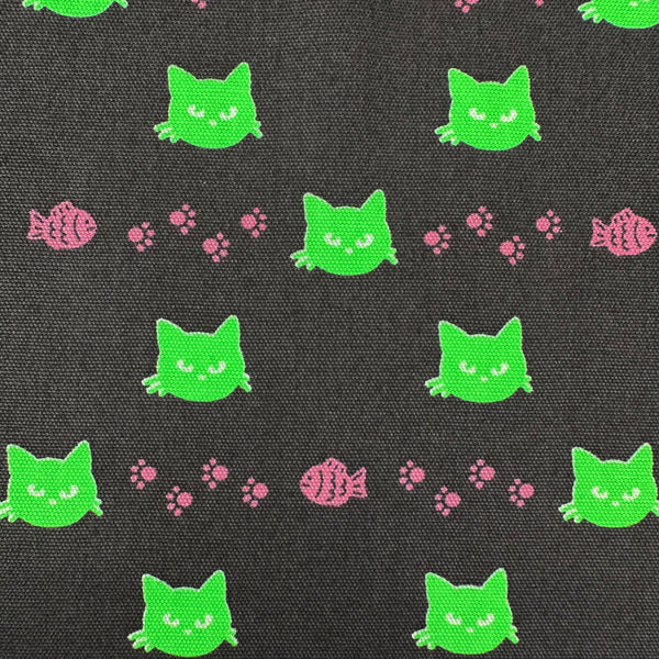 Close up of Neon Cat Cotton Oxford Fabric in Charcoal featuring a playful print of fish, paws, and neon cat faces, imported from Japan.