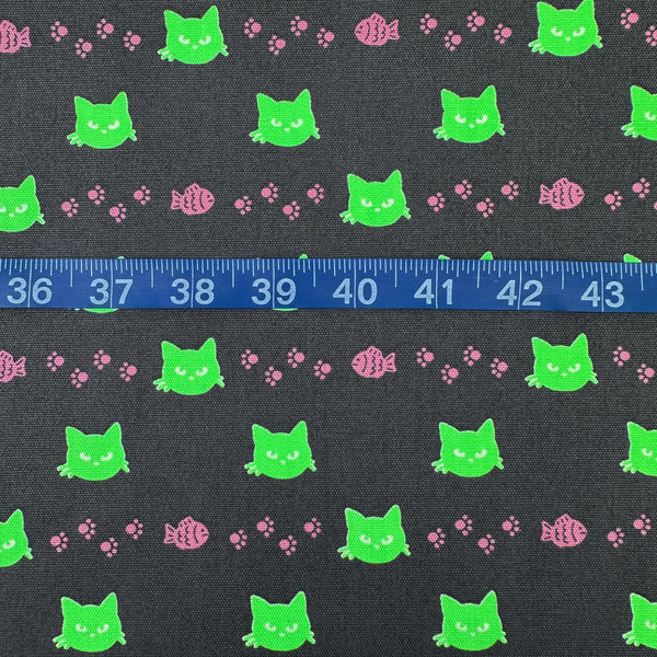 Scale of Neon Cat Cotton Oxford Fabric in Charcoal featuring a playful print of fish, paws, and neon cat faces, imported from Japan.