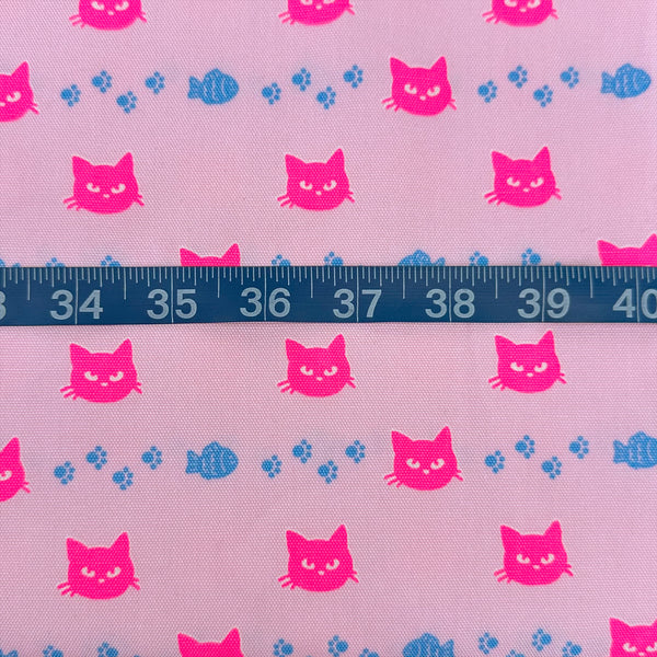 Scale of Neon Cat Cotton Oxford Fabric in Pink featuring a playful print of fish, paws, and neon cat faces, imported from Japan.