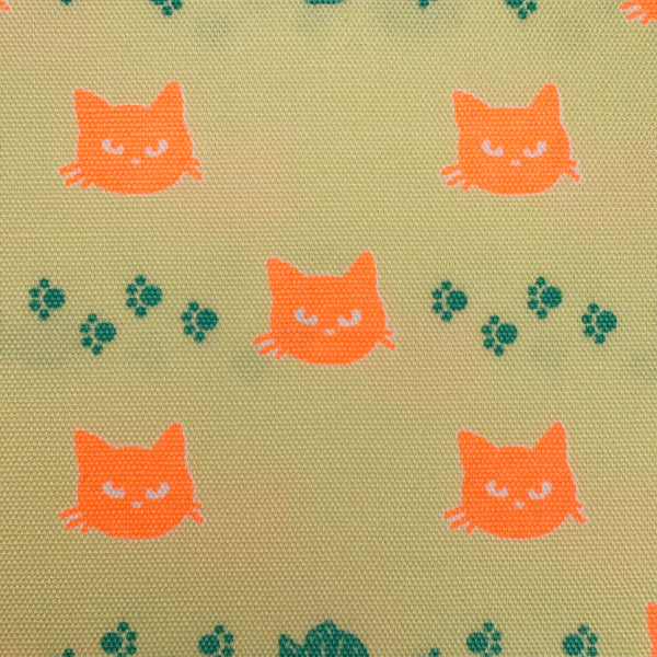 Close up of Neon Cat Cotton Oxford Fabric in Yellow featuring a playful print of fish, paws, and neon cat faces, imported from Japan.