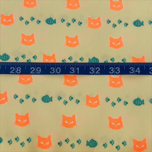 Scale of Neon Cat Cotton Oxford Fabric in Yellow featuring a playful print of fish, paws, and neon cat faces, imported from Japan.