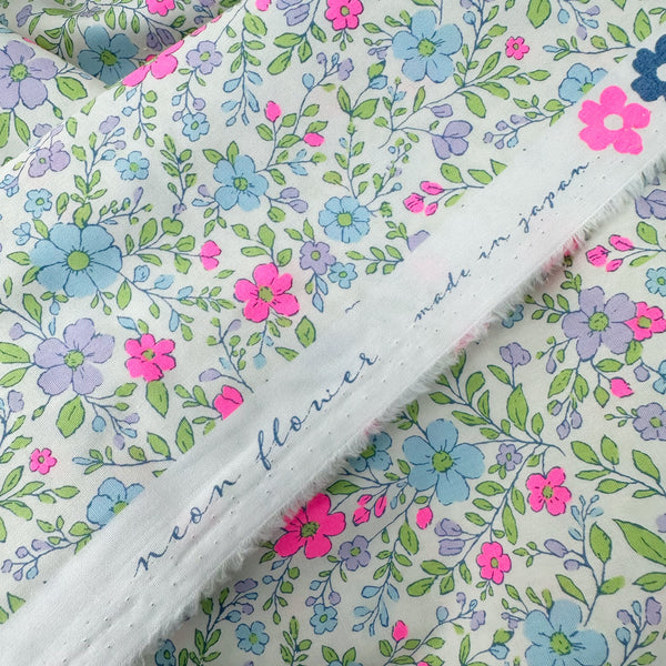 Selvage of Neon Flower Cotton Broadcloth Fabric in Natural featuring a vibrant floral print with neon accents, imported from Japan.
