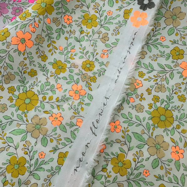 Selvage of Neon Flower Cotton Broadcloth Fabric in Orange featuring a vibrant floral print with neon accents, imported from Japan.