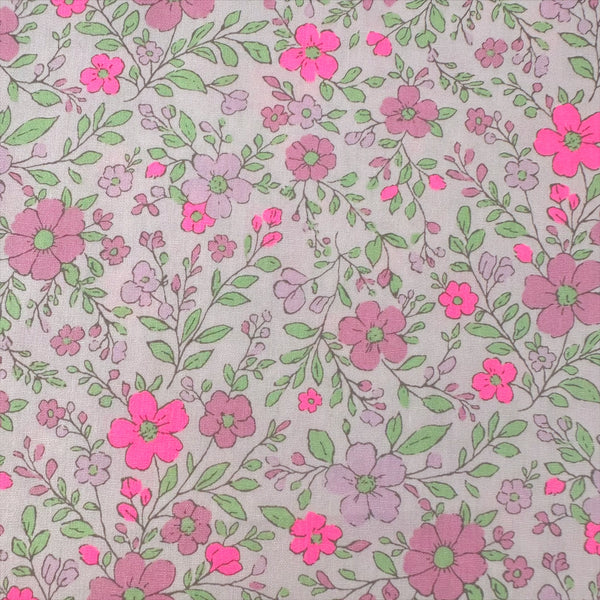 Close up of Neon Flower Cotton Broadcloth Fabric in Pink featuring a vibrant floral print with neon accents, imported from Japan.
