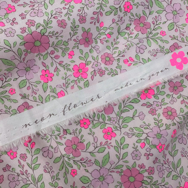 Selvage of Neon Flower Cotton Broadcloth Fabric in Pink featuring a vibrant floral print with neon accents, imported from Japan.