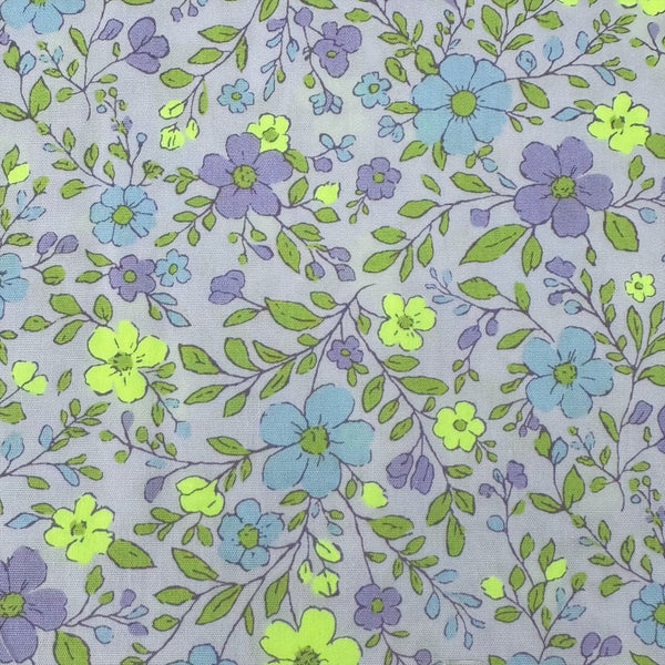 Close up of Neon Flower Cotton Broadcloth Fabric in Purple featuring a vibrant floral print with neon accents, imported from Japan.