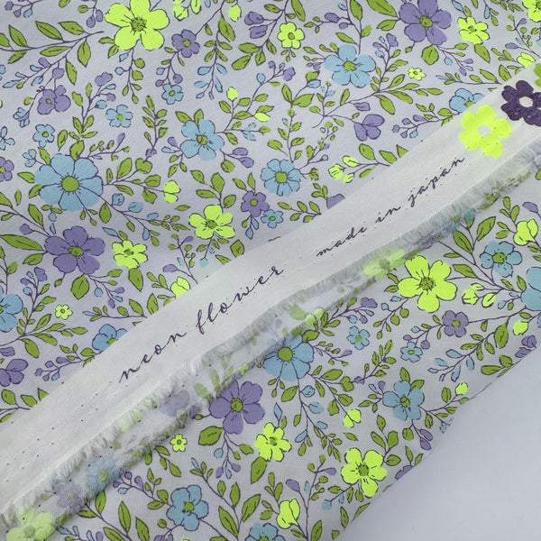 Selvage of Neon Flower Cotton Broadcloth Fabric in Purple featuring a vibrant floral print with neon accents, imported from Japan.
