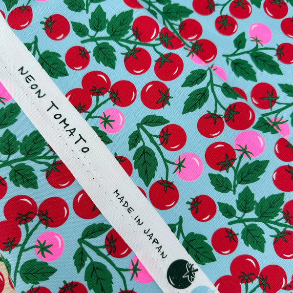 Selvage of Neon Tomato Cotton Oxford Fabric in Blue featuring a playful tomato print with neon accents, imported from Japan.