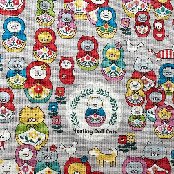Close up of Nesting Dolls Cats Cotton Canvas Fabric by Cotton Kobayashi, style KTS-7177D, featuring cat nesting doll illustrations, in gray, imported from Japan