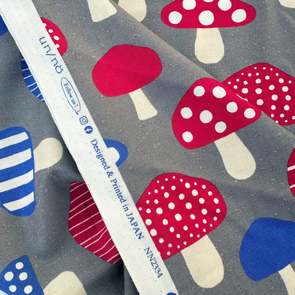 Selvage of Nordic Mushroom cotton fabric in gray by Cosmo Textiles featuring Scandinavian-inspired mushroom illustrations imported from Japan