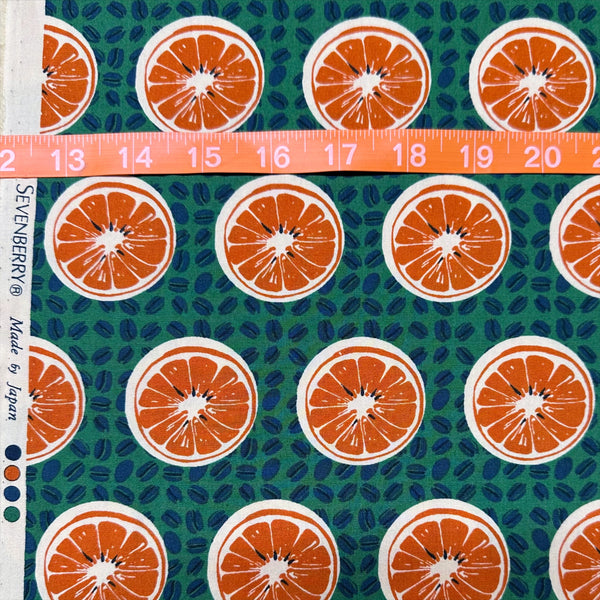 Scale of Oranges and Coffee Beans cotton broadcloth fabric in green by Sevenberry, Japanese import featuring fruit and coffee bean print