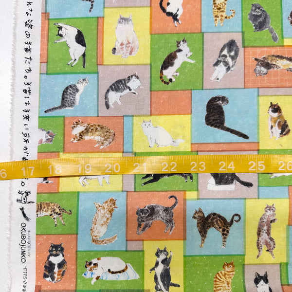 Scale of Paper Message Cats in Tiny Room Cotton Fabric by Okubo Junko for Kokka Japan, featuring cats arranged in blocks in blue, orange, and yellow.
