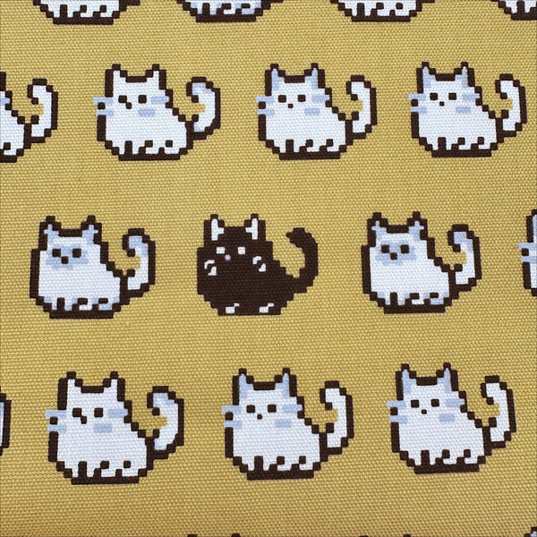 Close up of Pixel Cats cotton oxford fabric in golden mustard with playful pixel-style cat print, imported from Japan