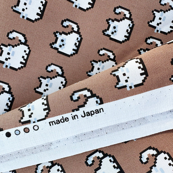 Selvage of Pixel Cats cotton oxford fabric in mocha with playful pixel-style cat print, imported from Japan