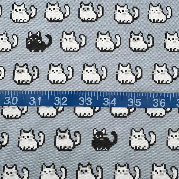 Scale of Pixel Cats gray cotton oxford fabric featuring a repeating pattern of pixel-style cat motifs arranged in rows.