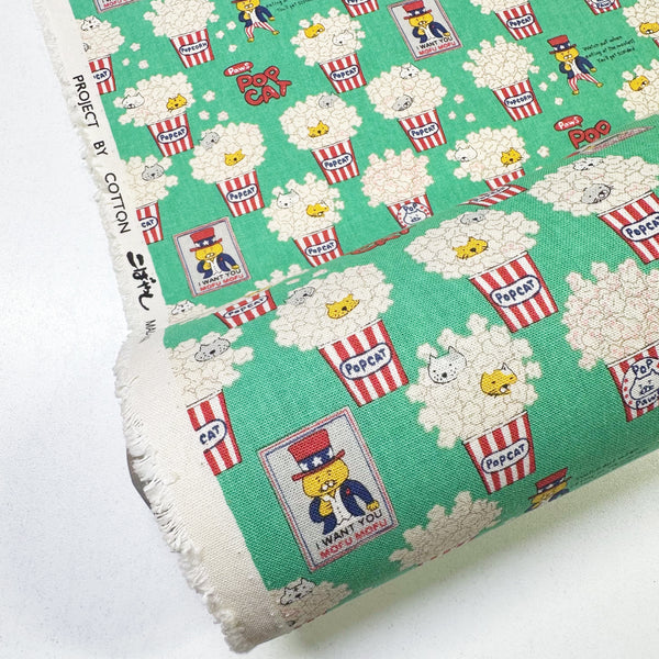 Bolt of Pop Cat canvas fabric in green cotton linen blend by Cotton Kobayashi featuring cats hiding in popcorn
