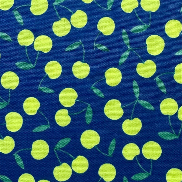 Close up of Pop Cherry Cotton Fabric in Navy and Neon Yellow featuring a bold cherry print, imported from Japan.