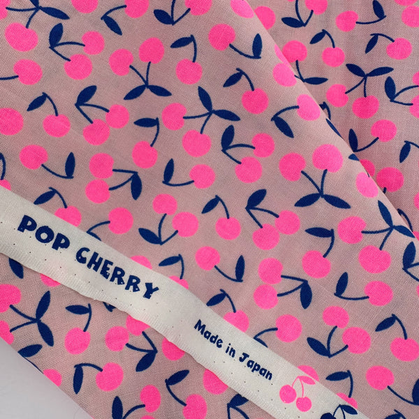 Selvage of Pop Cherry Cotton Fabric in Neon Pink and Navy featuring a bold cherry print, imported from Japan.