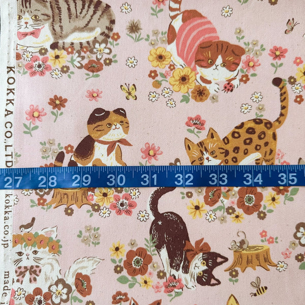Powerful Animal Cats Garden cotton oxford fabric by Kokka in pink, style YGA-81050-1 B, shown with a tape ruler for scale