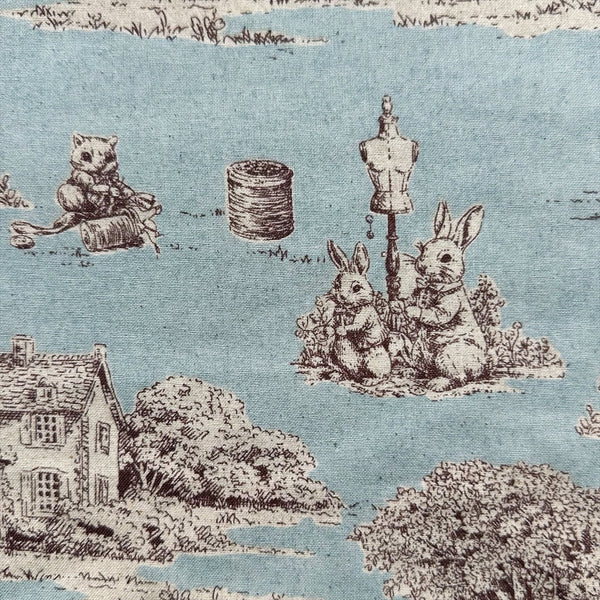 Close up of Rabbit Toile de Jouy cotton fabric in blue