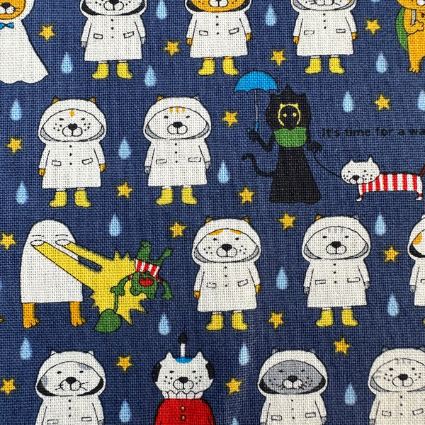 Close up of Raincoat Cats Cotton Canvas fabric by Cotton Kobayashi, style KTS-7194D, in navy