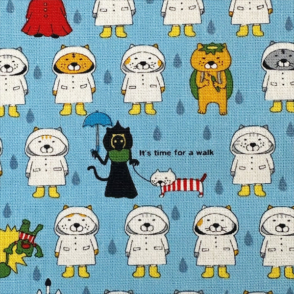 Close up of Raincoat Cats cotton canvas fabric by Cotton Kobayashi in sky blue