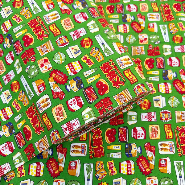 Bolt of Retro Japanese Grocery cotton Oxford fabric by Cosmo Textiles featuring vintage-inspired Japanese food packaging and grocery motifs on a green background