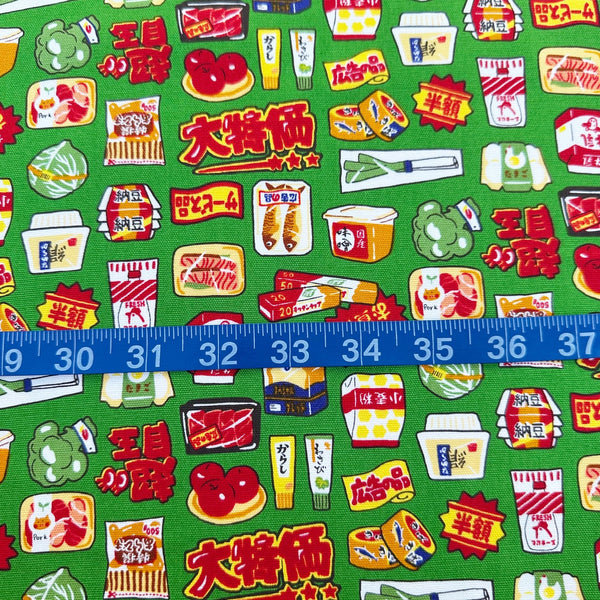 Scale of Retro Japanese Grocery cotton Oxford fabric by Cosmo Textiles featuring vintage-inspired Japanese food packaging and grocery motifs on a green background
