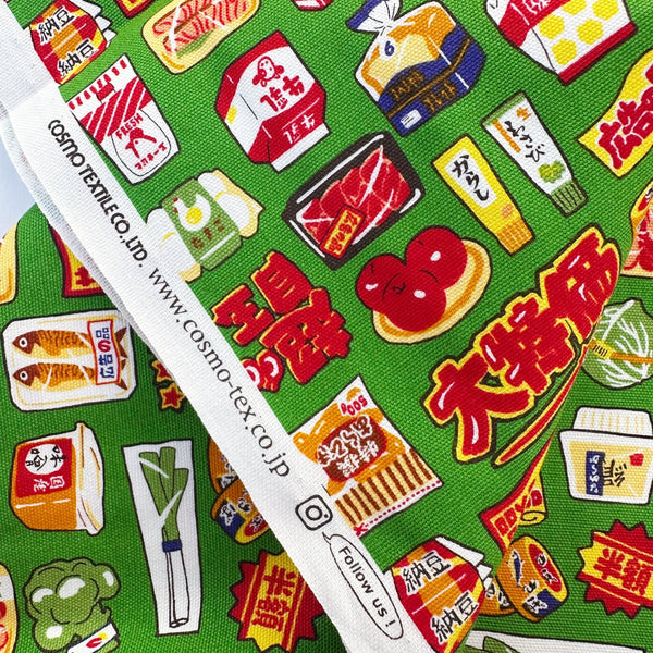 Selvage of Retro Japanese Grocery cotton Oxford fabric by Cosmo Textiles featuring vintage-inspired Japanese food packaging and grocery motifs on a green background