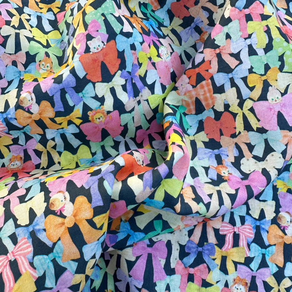 Drape of Ribbon Collector Cotton Lawn Fabric in Navy by Yukiemon for Hokkoh featuring whimsical ribbons and charming illustrated motifs on soft Japanese cotton lawn.