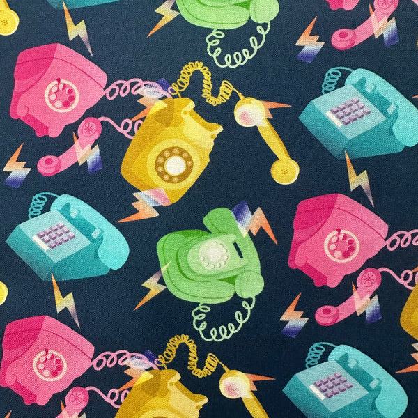 Close up of Ring, Ring cotton fabric by Nora featuring tossed vintage telephones on a blue background, imported from Japan